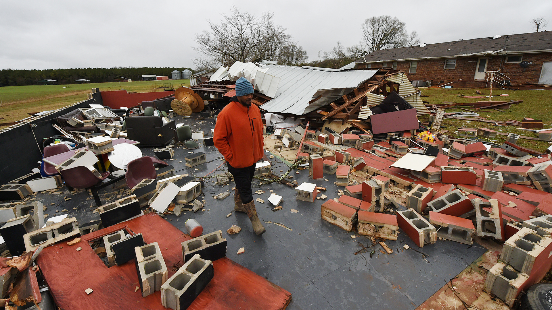 Residents in Lawrence County, AL, walk through the destruction caused by powerful storms and suspected tornadoes that tore through the Deep South on Monday.
