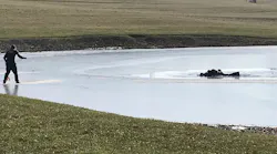 East Wayne, OH, firefighters work to rescue a man and his two grandsons after they fell through ice at a small pond near the village of Dalton on Sunday.
