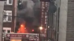 FDNY firefighters help residents on the fire escape of a burning three-story apartment building early Monday in the East New York neighborhood of Brooklyn.