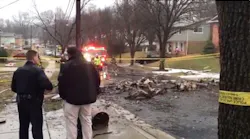 Officials gather at the scene after a plane crashed into a New Carrollton home Sunday.