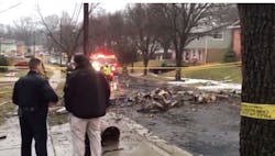 Officials gather at the scene after a plane crashed into a New Carrollton home Sunday.