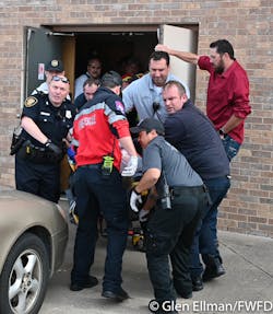 Firefighters, police and paramedic remove a victim from the scene of a shooting at a White Settlement church Sunday morning.