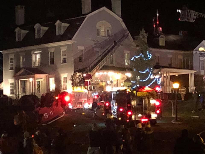 A firefighter dressed as Santa operates an aerial ladder during the fire at the 1820 House in Simsbury.