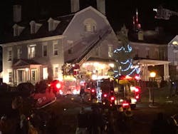 A firefighter dressed as Santa operates an aerial ladder during the fire at the 1820 House in Simsbury.