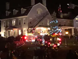 A firefighter dressed as Santa operates an aerial ladder during the fire at the 1820 House in Simsbury.
