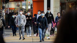 Chinese residents wear surgical masks while crossing the road in order to prevent the spread of the Wuhan coronavirus Thursday in Hong Kong.