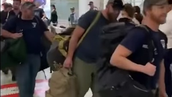 U.S. firefighters are welcomed with applause after landing in Sydney on Thursday. The group is part of about 100 firefighters who will be helping to battle the devastating wildfires raging across Australia.
