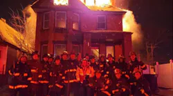 Detroit firefighters pose in front of a burning home on New Year's Eve in a photo that was posted on social media.