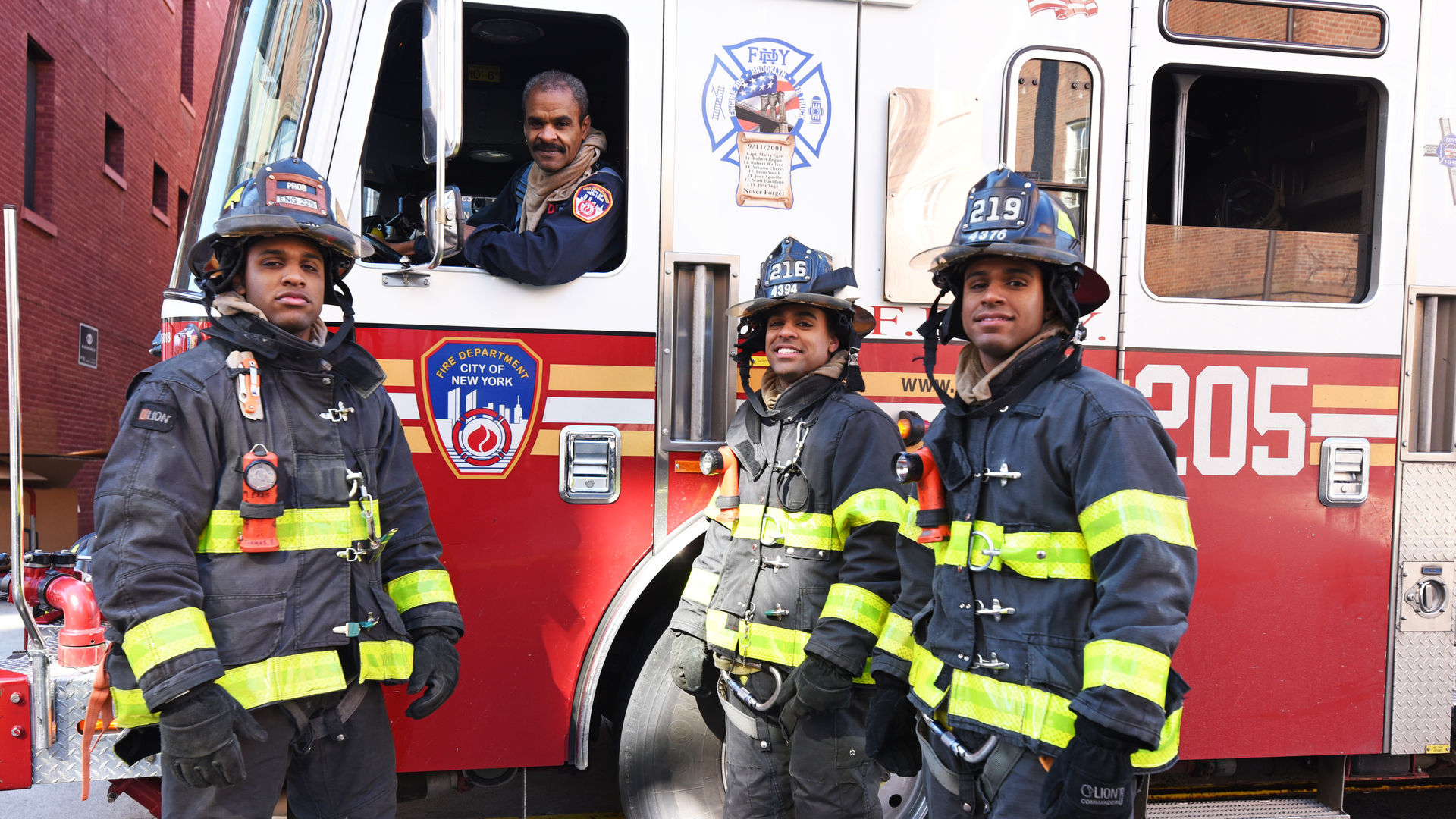 FDNY firefighter Robert Thomas, 61 (seated in apparatus), and his firefighting sons, Stephen Thomas, 25; Jason Thomas, 29; and Nathan Thomas, 27.