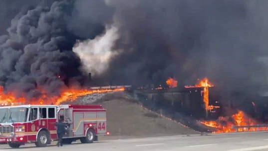 Flames burned a 500-foot path after a tanker carrying 4,000 gallons of fuel rolled over and caught fire on an interstate ramp in Indianapolis on Thursday.