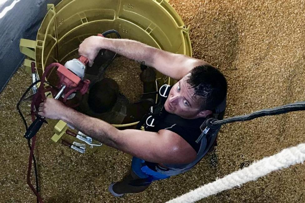 A firefighter works to free a farmer trapped in corn in a Burlington, IA, silo in May 2018.