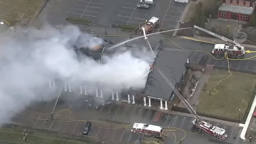 Firefighters battle a large blaze that tore through multiple businesses at a Cherry Hill, NJ, strip mall Friday.