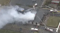 Firefighters battle a large blaze that tore through multiple businesses at a Cherry Hill, NJ, strip mall Friday.