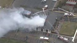Firefighters battle a large blaze that tore through multiple businesses at a Cherry Hill, NJ, strip mall Friday.