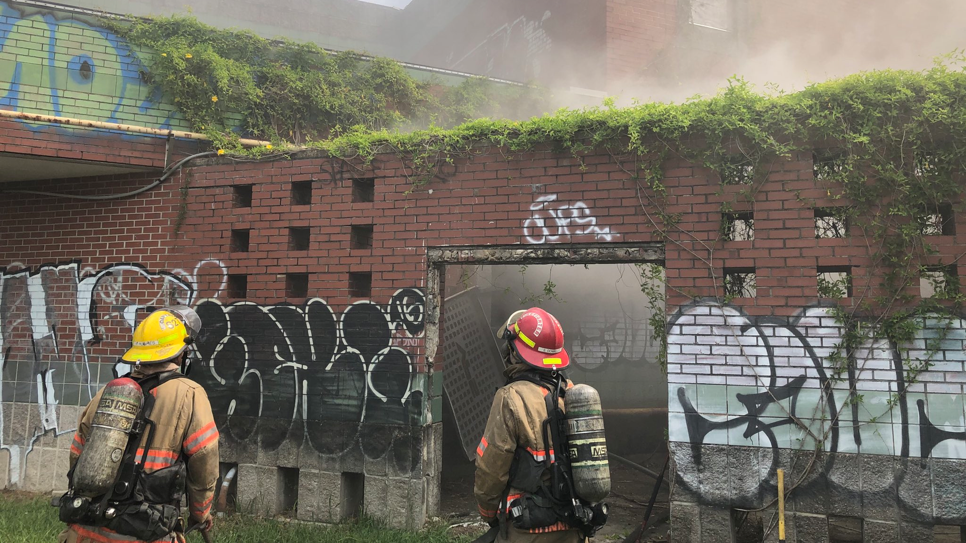 New Orleans firefighters cut away locks and coverings at the former Moton Elementary School in order to put out a two-alarm blaze Monday.