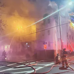 Firefighters from Lynn, MA, and the surrounding area battled a blaze that broke out at a triple-decker house late Wednesday and spread to a nearby building.