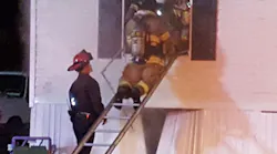Firefighters remove the victim from the burning mobile home.