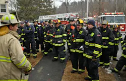 Under new protocol, firefighters listen to comments by a chief after they fought a 2-alarm fire at 63 Overlook Drive in Worcester. The fire displaced about 30 people on Feb. 18.