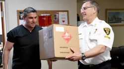 Former Canton, OH, firefighter/paramedic Rosario Carcione (left), who now is pharmacy manager at Compounding Pharmacy of Green, donated Monday bottles of hand sanitizer to Fire Chief Tom Garra..
