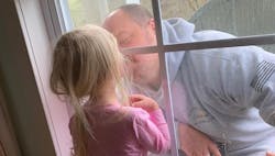 A quarantined Huntersville, NC, firefighter gives his daughter a window kiss earlier this month. A quarantined Huntersville, NC, firefighter gives his daughter a window kiss earlier this month.