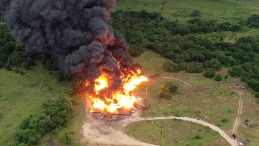Mid-County, TX, firefighters contained a massive blaze that was sparked by lightning possibly striking oil tanks in Caldwell County early Wednesday.