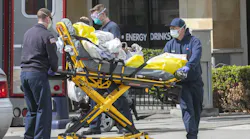 Firefighters and paramedics attend to a patient in downtown San Diego wearing face, hand and eye protective gear on Wednesday, April 8, 2020.