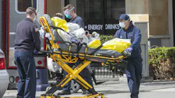 Firefighters and paramedics attend to a patient in downtown San Diego wearing face, hand and eye protective gear on Wednesday, April 8, 2020.