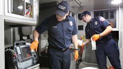 Massilon firefighter/paramedics Anthony Lumpp (left) and Brian Frank sanitize the interior of a medic unit at Fire Station No. 1 in Massillon, OH, on Friday, April 3, 2020.