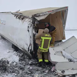 Finley, ND, firefighters take boxes of personal protective equipment from a wrecked tractor-trailer April 2 in order to deliver them to two rural hospitals.