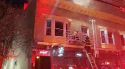 Rochester firefighters use a hand ladder to rescue a resident during a four-alarm fire on Tuesday, April 28, 2020.