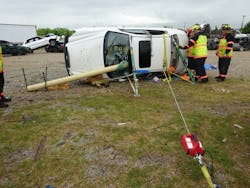 This training scenario called for the undercarriage of the vehicle to be out-of-play (obstructed and inaccessible to rescuers). Tactics employed here for this side-resting, side-obstructed scenario included using two struts, tie-down straps, rescue chain and a portable electric winch for the pulling effort. The pole was secured by a creative use of crossed pickets on the ground, along with cribbing, step chocks and ratchet tie downs.