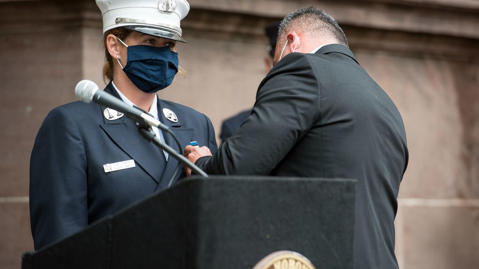Hoboken, NJ, Office of Emergency Management Director Sgt. William Montanez pins the badge on his fianc&eacute;e, Audra Carter, who becomes the first woman in the fire department's 171-year history to become battalion chief.