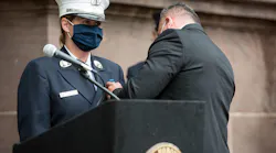 Hoboken, NJ, Office of Emergency Management Director Sgt. William Montanez pins the badge on his fiancée, Audra Carter, who becomes the first woman in the fire department's 171-year history to become battalion chief.