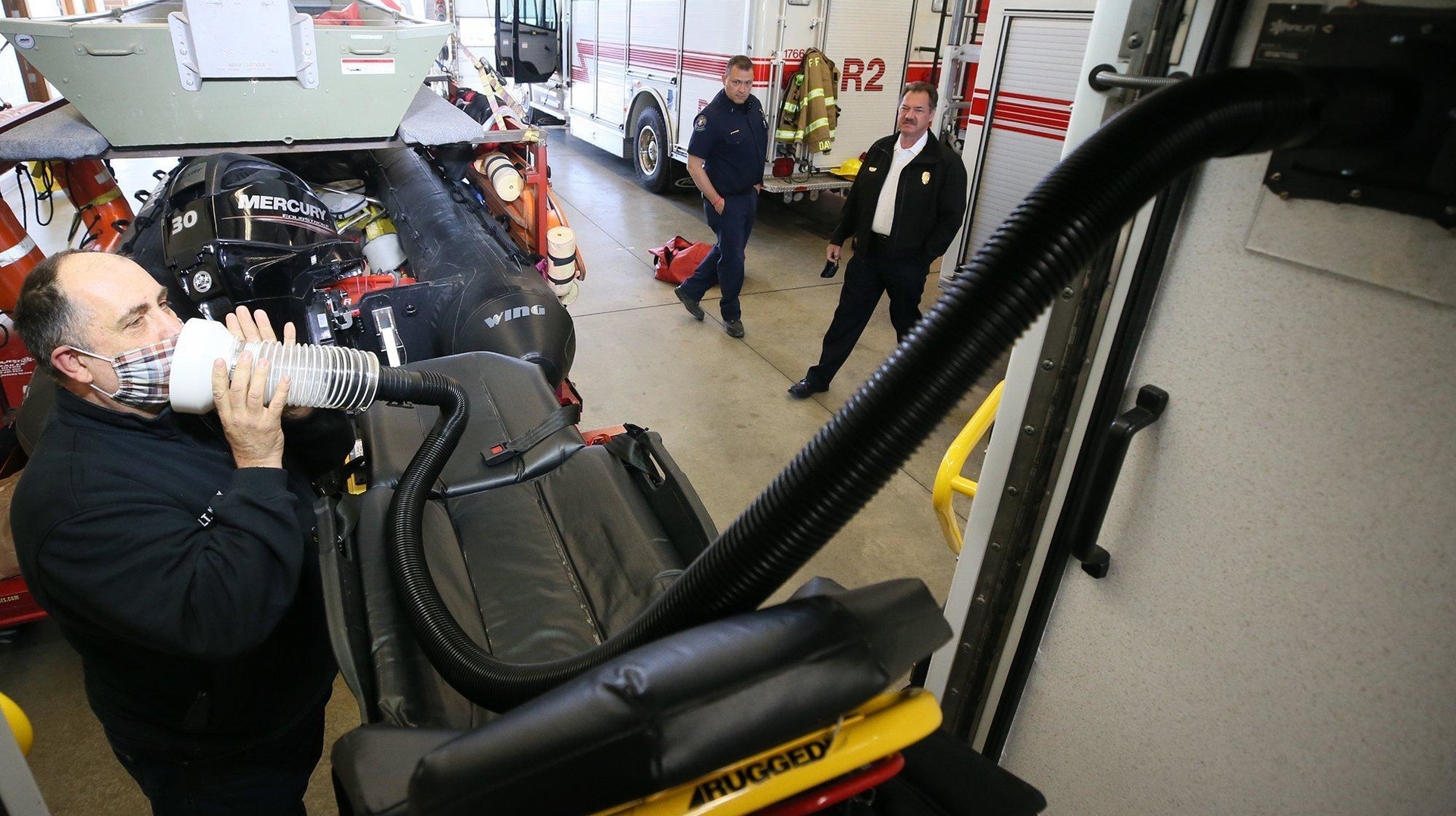 Cuyahoga Falls Fire Lt. Rick Malak demonstrates his squad's air exhaust attachment that patients hold up to their face to expel exhales into the hose and out the cabin exhaust system.