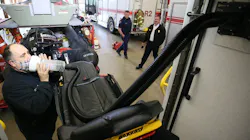Cuyahoga Falls Fire Lt. Rick Malak demonstrates his squad's air exhaust attachment that patients hold up to their face to expel exhales into the hose and out the cabin exhaust system.