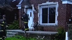 Detroit firefighters kicked down a door to rescue two boys inside a burning house Saturday. Detroit firefighters kicked down a door to rescue two boys inside a burning house Saturday.