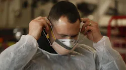 Sam Sprankle, a firefighter/paramedic with the Green, OH, Fire Department puts on the N95 mask and surgical mask that he and other EMS personnel will wear while working with COVID-19 patients.