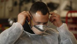 Sam Sprankle, a firefighter/paramedic with the Green, OH, Fire Department puts on the N95 mask and surgical mask that he and other EMS personnel will wear while working with COVID-19 patients. Sam Sprankle, a firefighter/paramedic with the Green, OH, Fire Department puts on the N95 mask and surgical mask that he and other EMS personnel will wear while working with COVID-19 patients.