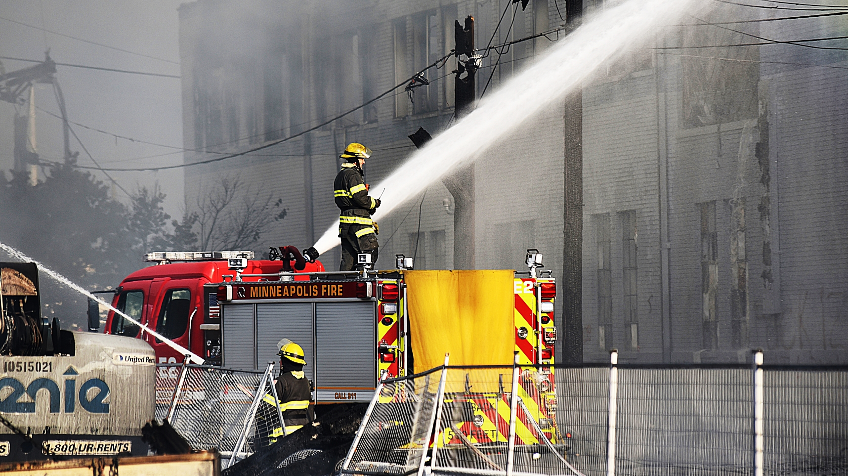 Minneapolis firefighters hose down a building Thursday after fires erupted throughout the city following protests in the wake of the death of George Floyd.