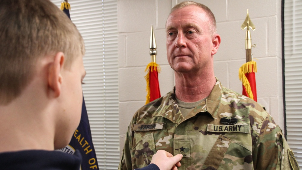 The son of Lexington, KY, Battalion Chief Rob Larkin pins the rank of brigadier general onto his father&rsquo;s chest during a promotion ceremony in Frankfort in March.