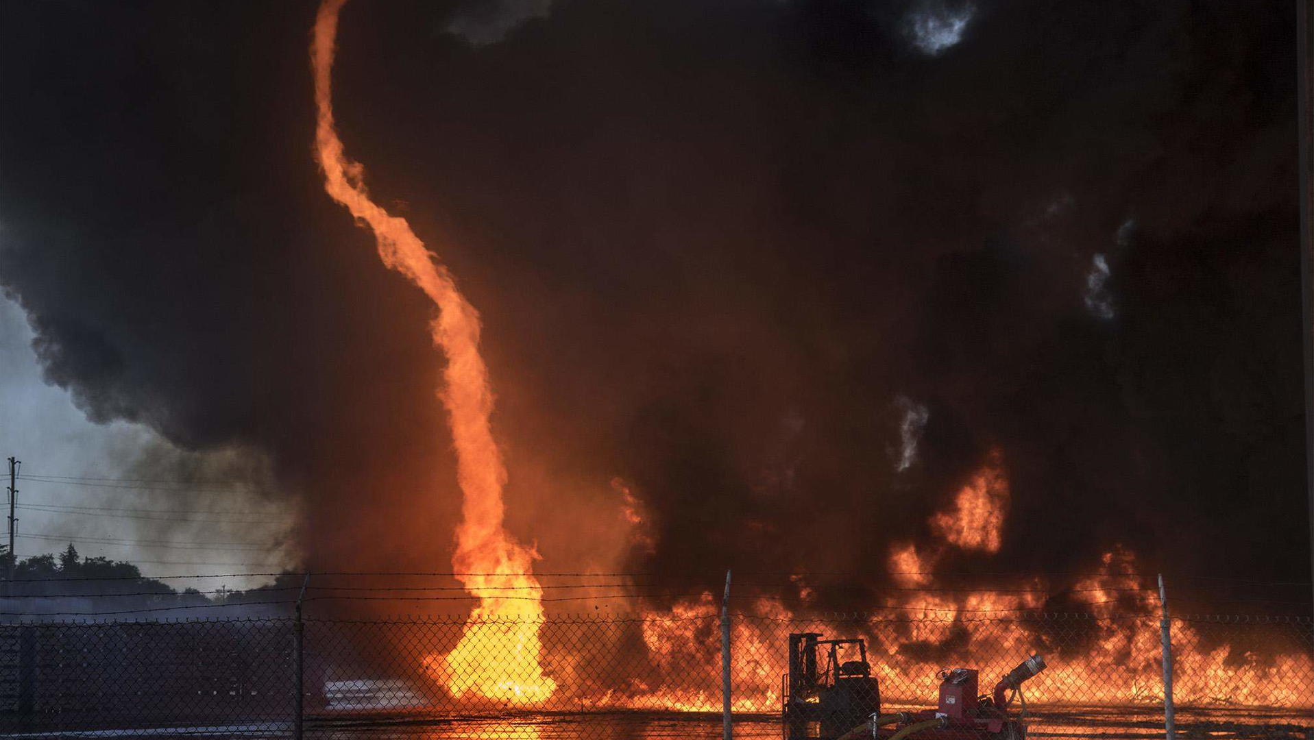 A fire tornado erupts during a plastic pallet fire at the former Mizkan America facility on D Street near Poplar Street in east Stockton, CA, on Tuesday.