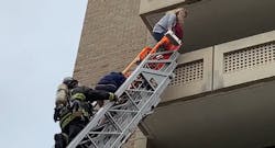 A D.C. Fire and EMS firefighters helps two occupants to safety from an aerial ladder. A D.C. Fire and EMS firefighters helps two occupants to safety from an aerial ladder.