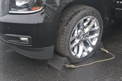 Plastic wheel chocks that are connected by a rope are positioned at the front and rear of one tire to prevent unwanted forward and rearward movement. Plastic wheel chocks that are connected by a rope are positioned at the front and rear of one tire to prevent unwanted forward and rearward movement.