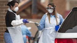 Workers conduct drive-through COVID-19 testing in a parking lot in Chicago on April. Workers conduct drive-through COVID-19 testing in a parking lot in Chicago on April.