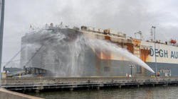 Jacksonville, FL, firefighters spray the sides of an auto-hauling cargo ship as fire continues to burn inside. Jacksonville, FL, firefighters spray the sides of an auto-hauling cargo ship as fire continues to burn inside.