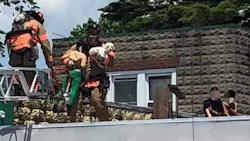 Kingston, NY, firefighters rescue three children and a dog from the roof of a burning apartment building Thursday.