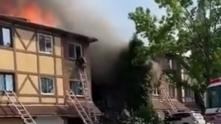 A Philadelphia firefighter escapes the flames from the third story of a burning residential building during a three-alarm blaze Thursday.