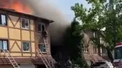 A Philadelphia firefighter escapes the flames from the third story of a burning residential building during a three-alarm blaze Thursday.