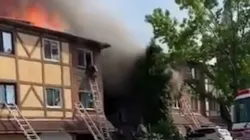 A Philadelphia firefighter escapes the flames from the third story of a burning residential building during a three-alarm blaze Thursday.