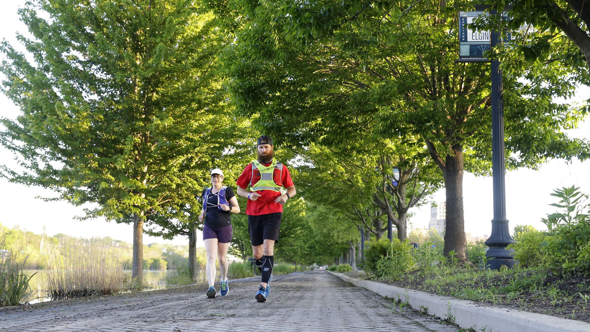 Former Woodstock, IL, firefighter Ryan Mains runs with pace runner Leann McMonigan along the Fox River Trail on Saturday in Elgin. After months of training, he was making an 80-mile run to raise $18,000 to help first responders struggling with PTSD.